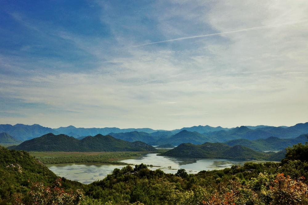 a scenic view of a lake surrounded by mountains