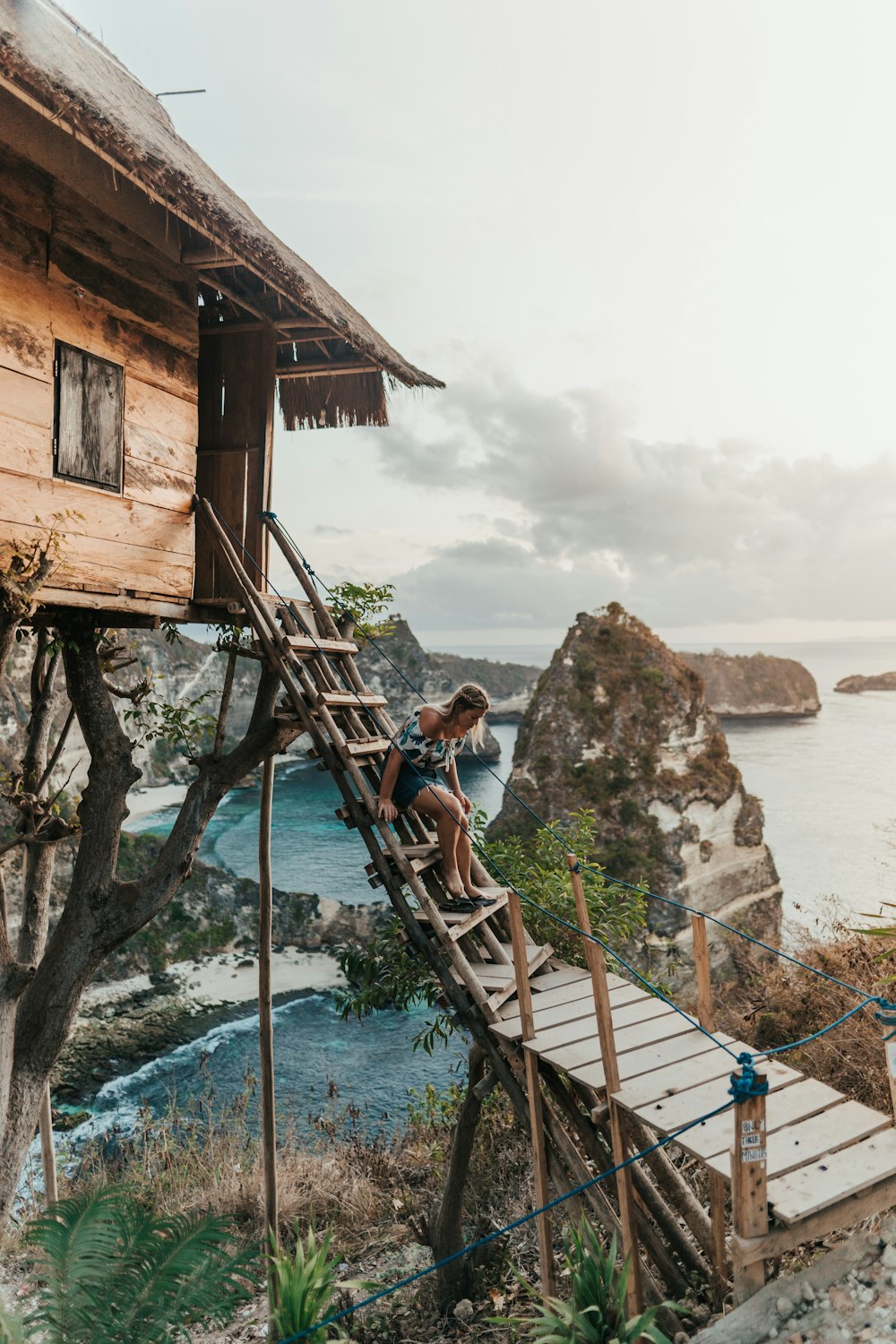 woman stepping and going down on stairs viewing mountain and body of water