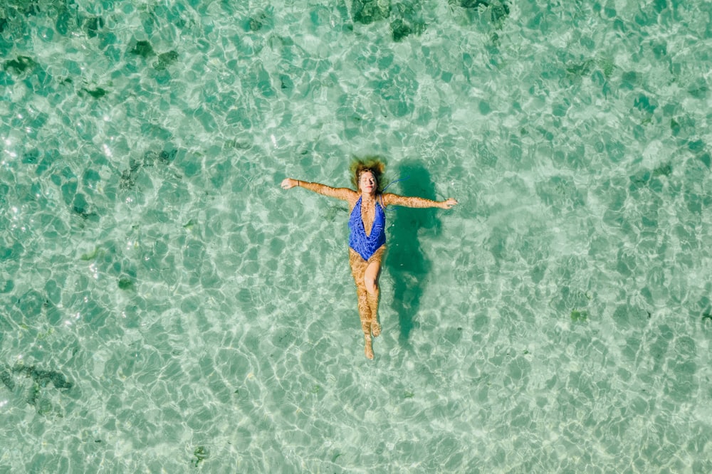 woman wearing blue one-piece bikini on the body of water