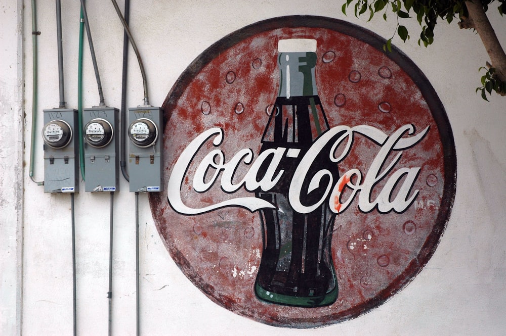 red and white Coca-Cola wall decor near electric reader