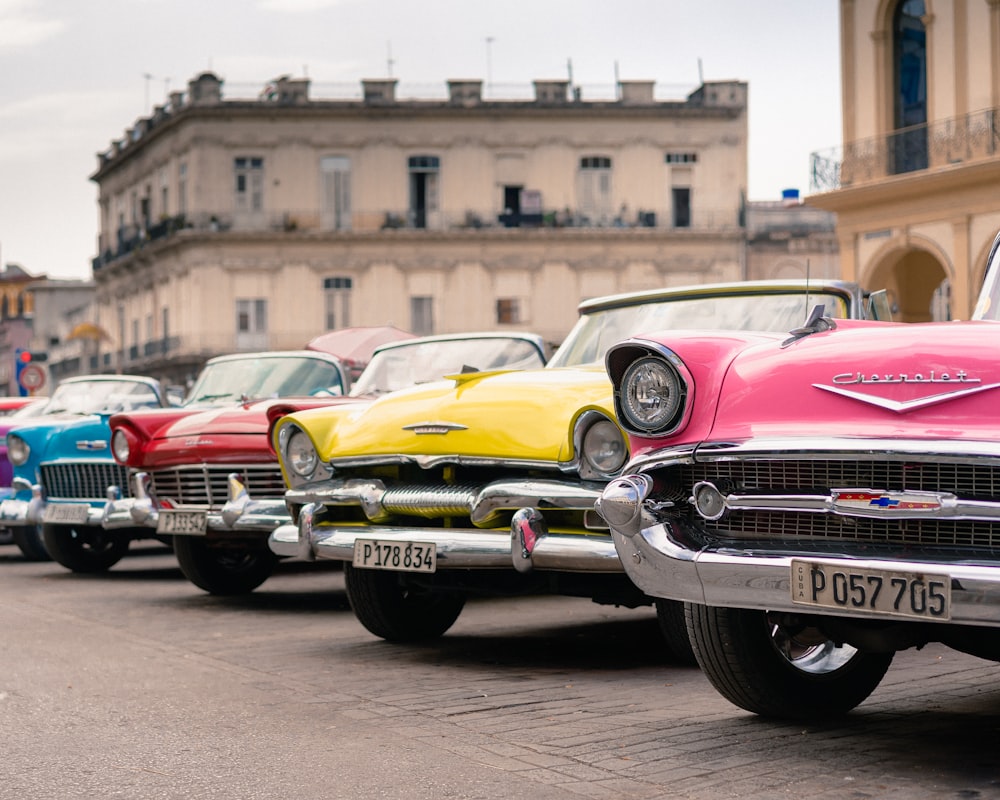 assorted-colored antique cars parking near road