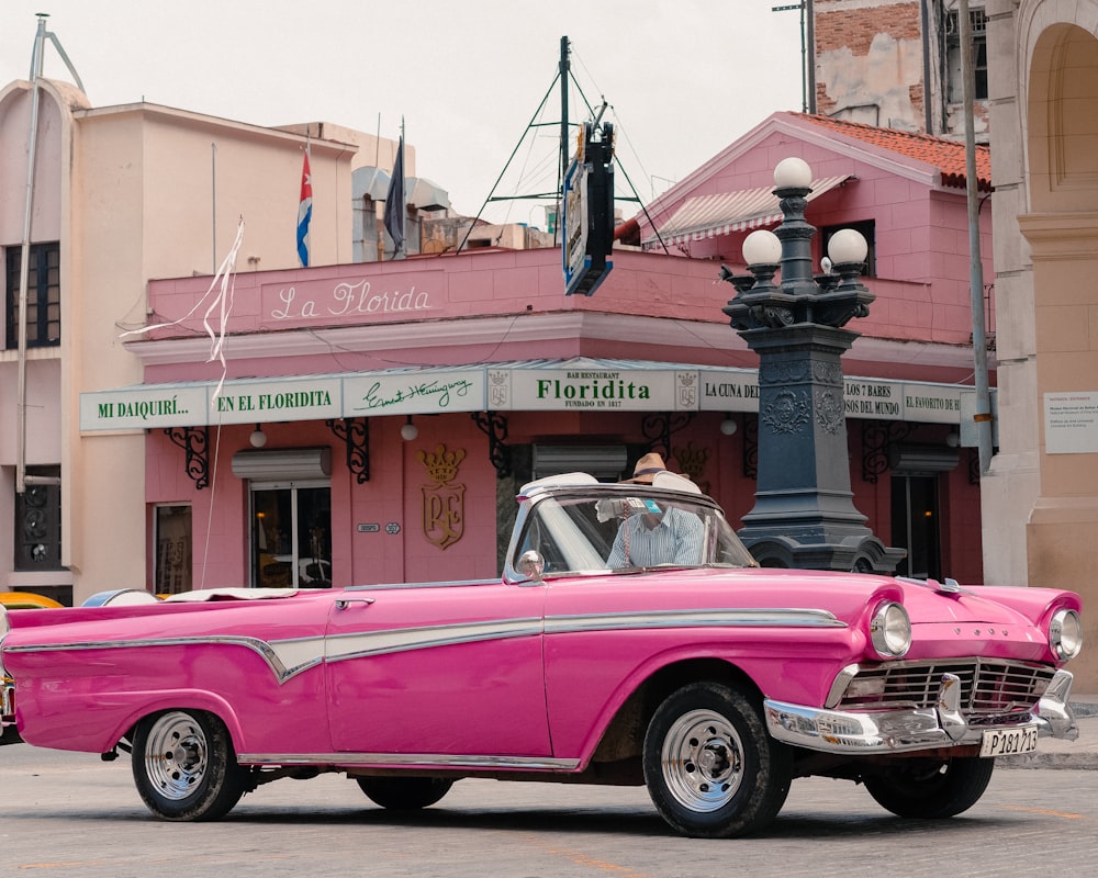 man riding on the pink coupe