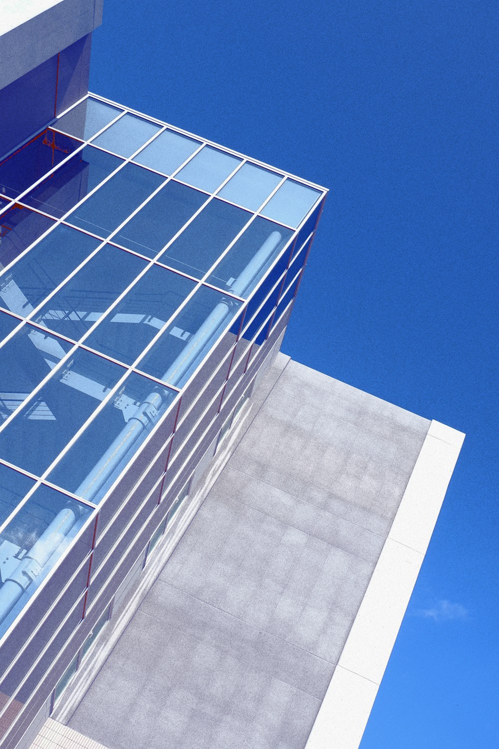 Fotografia dal basso di un grattacielo con pareti in vetro bianco e blu