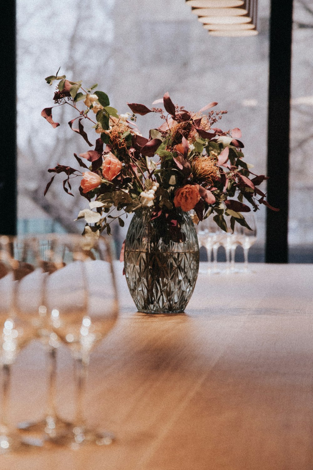 갈색 테이블에 빨간 꽃잎이 달린 꽃 센터피스