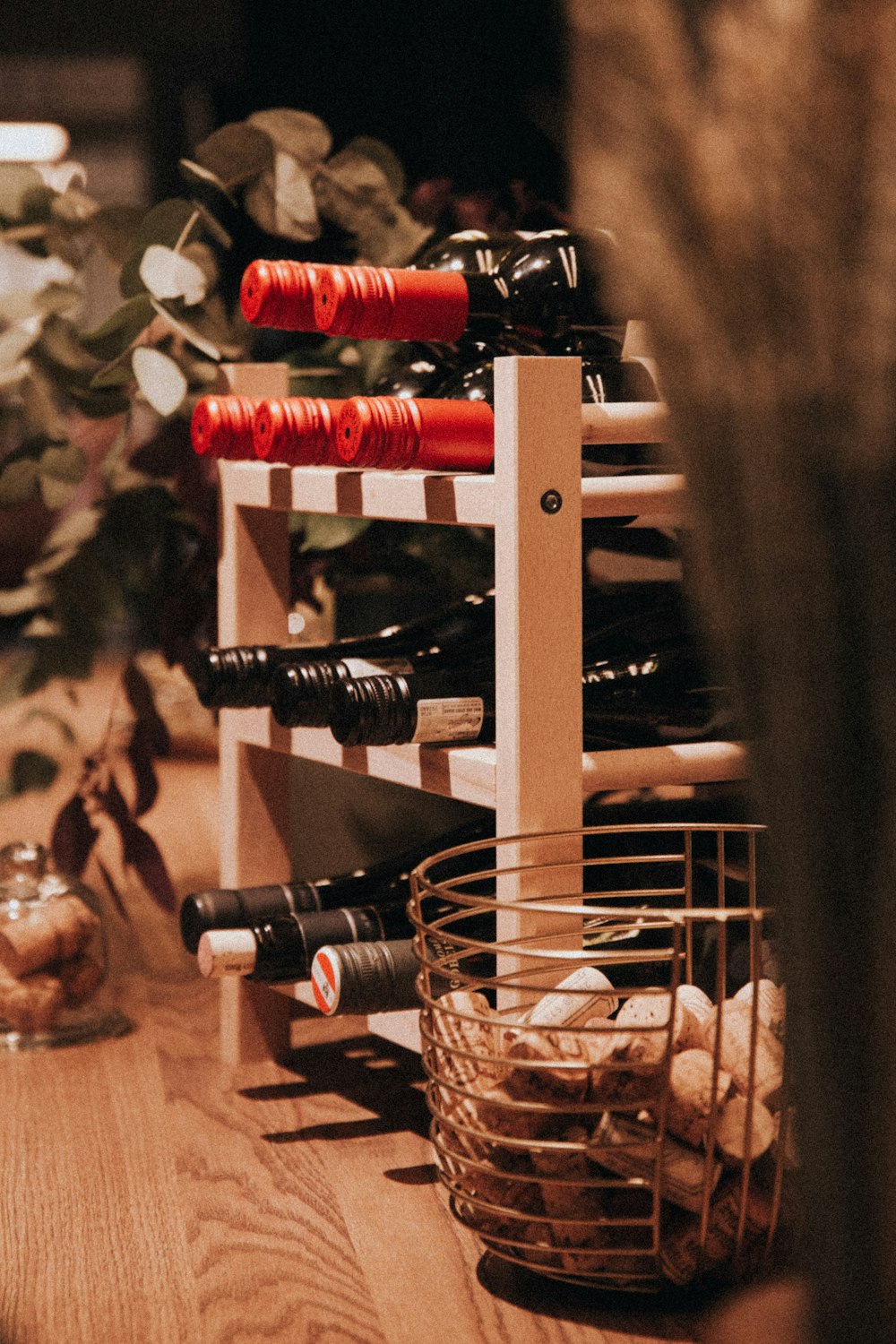 brown wine corks in steel basket near wine bottles on shelf