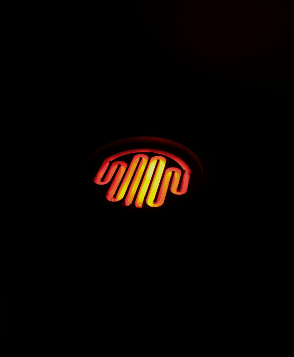 a red and yellow neon sign in the dark