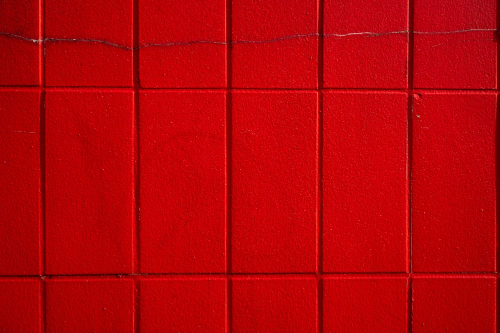 a close up of a red tiled wall