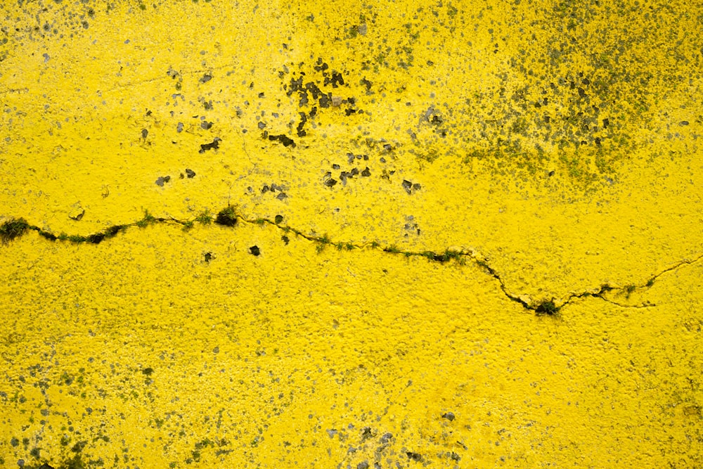 a yellow wall with a crack in it