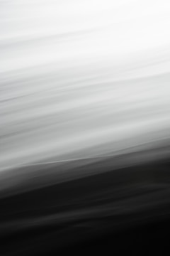 Abstract blurred lines creating a gradient from white to black, with smooth transitions and a sense of motion.