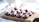 Close-up of rich, glossy homemade chocolates arranged on a rustic wooden board.