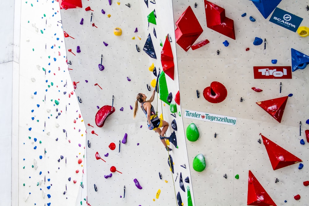 photography of woman doing wall climbing during daytime