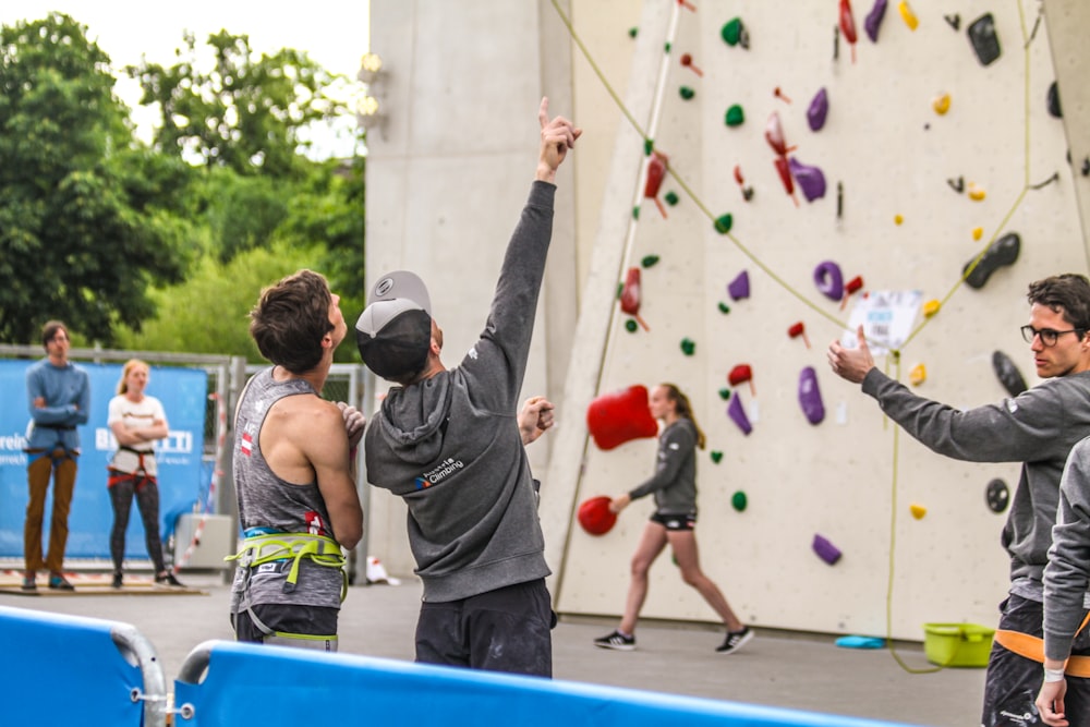 people standing beside rock climbing wall