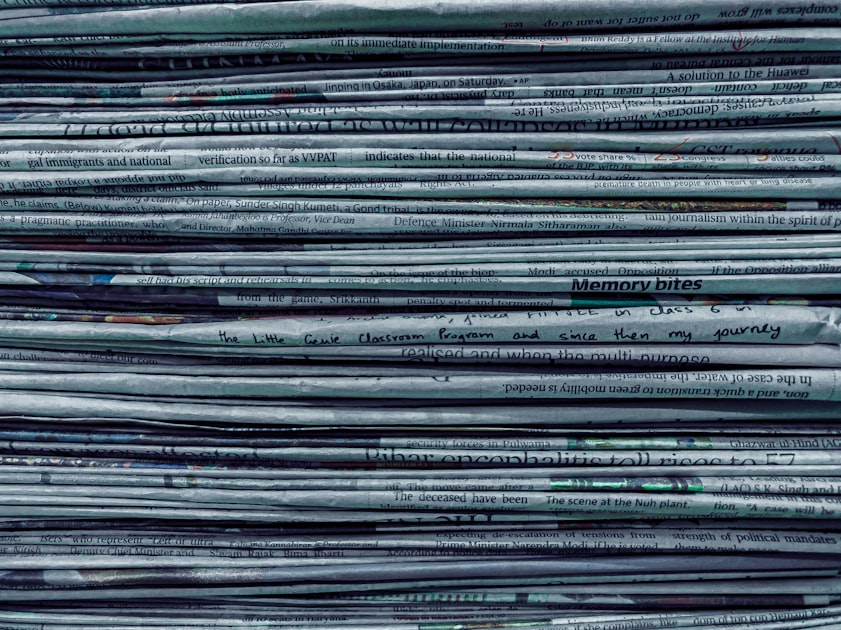 A large pile of stacked newspapers, representing the published articles and reports that AI research agents can read and synthesize