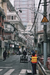A technician carefully cleaning a traffic sign along a busy city street.