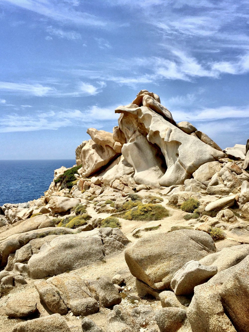 photography of stones beside body of water during daytime