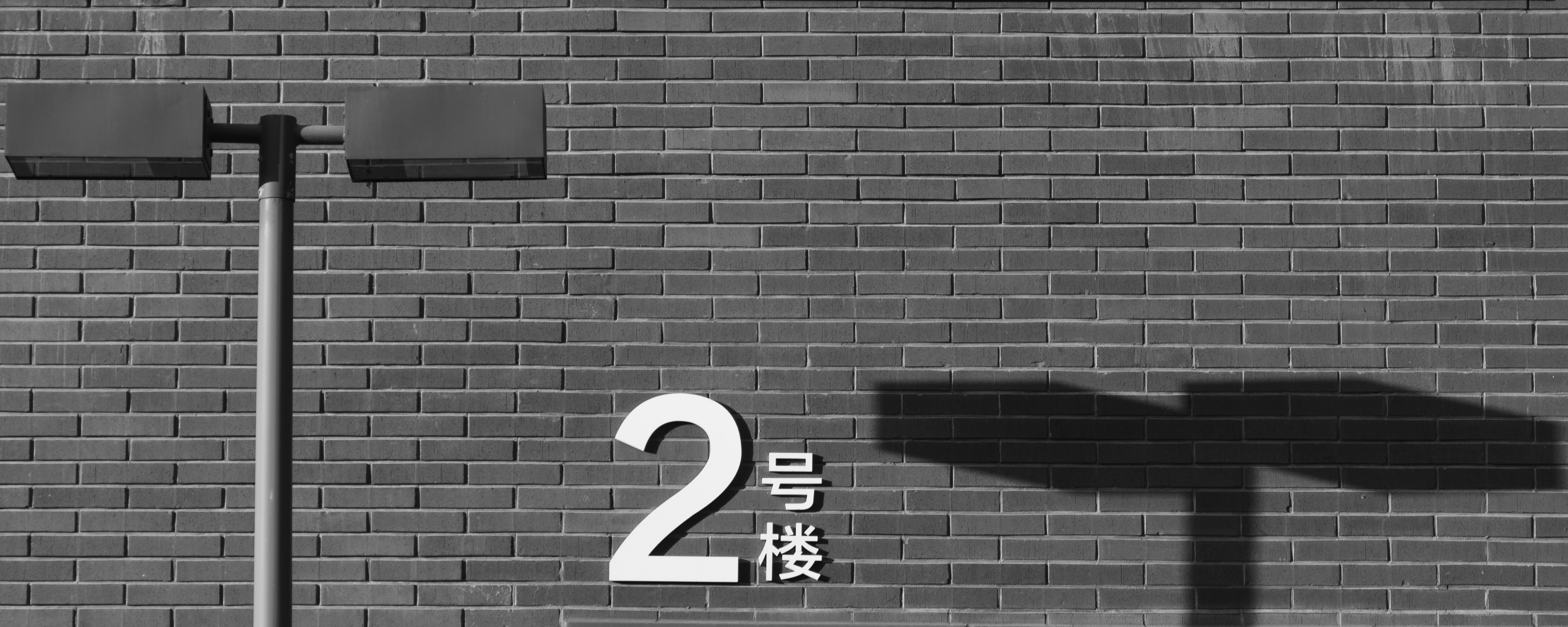 grayscale photography of concrete wall near post