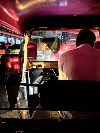 man in pink dress shirt sitting on driver's seat