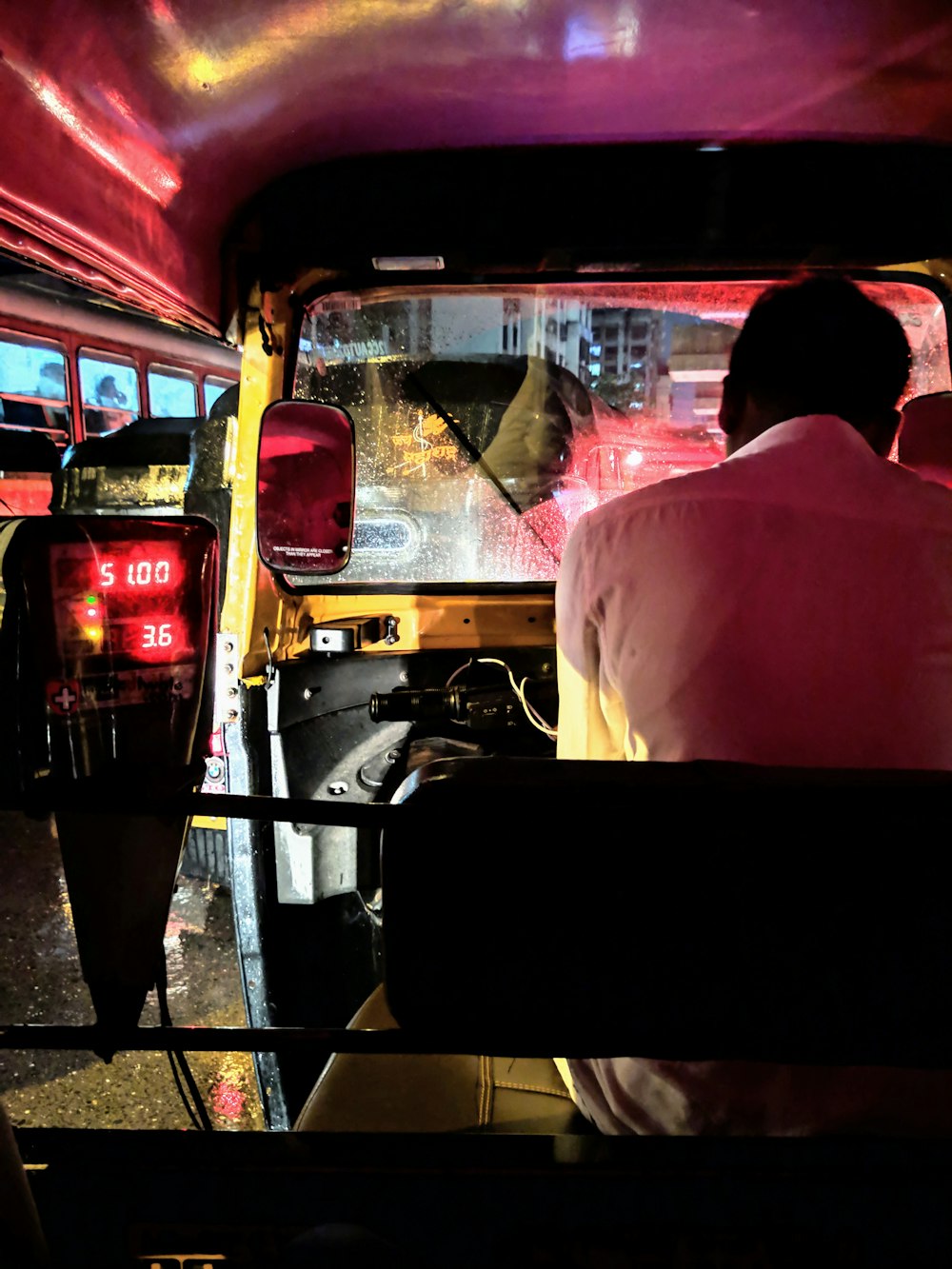 man in pink dress shirt sitting on driver's seat