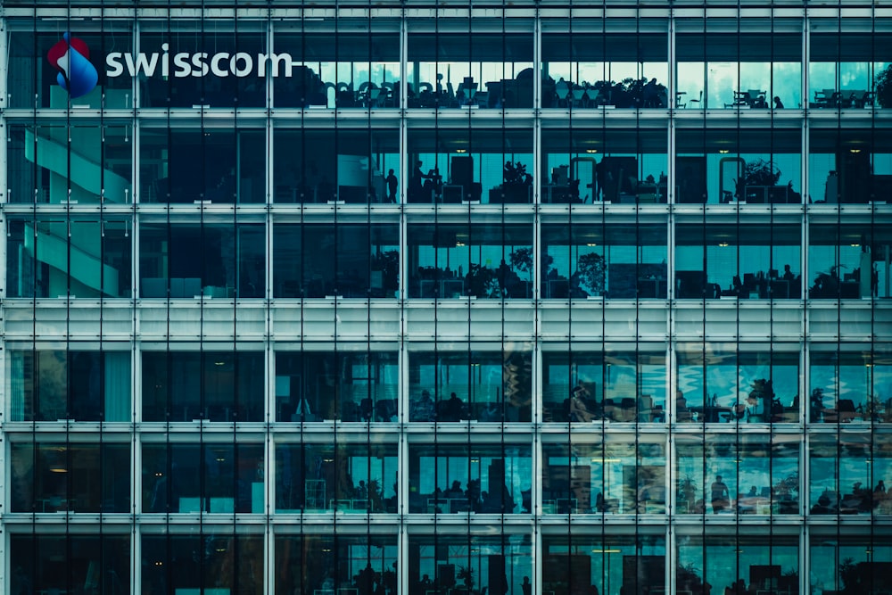a large glass building with a swisscom logo on it