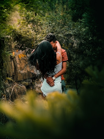 Couple enjoying a relaxing massage outdoors surrounded by forest greenery.