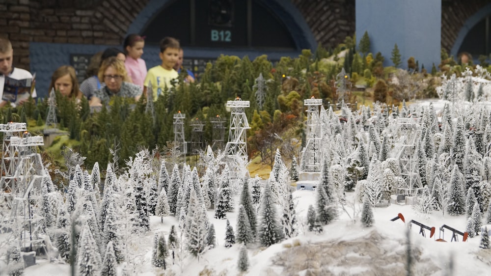 a group of people looking at a model train set