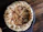 Close-up of a happy customer enjoying a slice of artisanal pizza in a cozy restaurant setting.