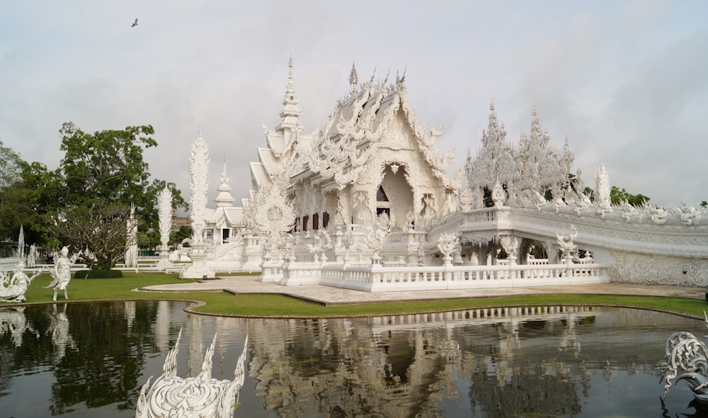 white concrete cathedral near body of water