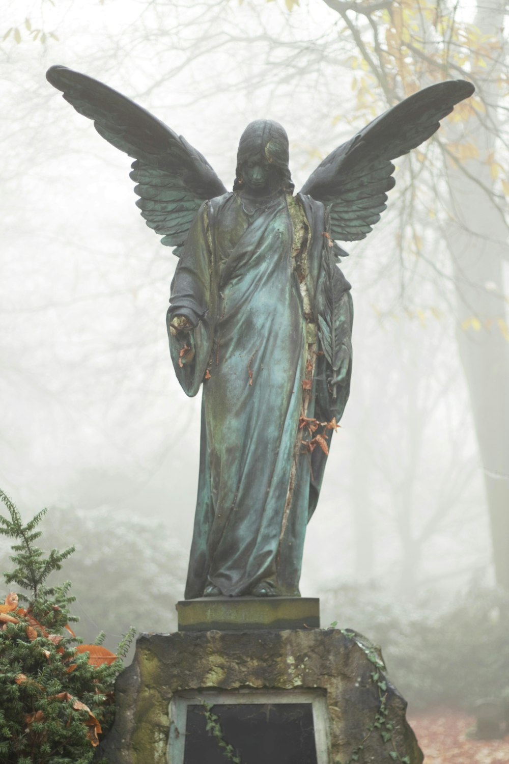 Ángel con túnica gris estatua durante el día