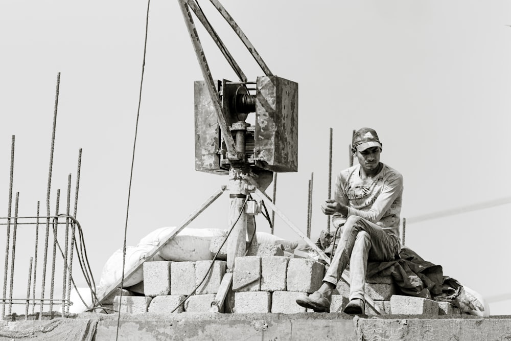 grayscale photography of man sitting outdoors