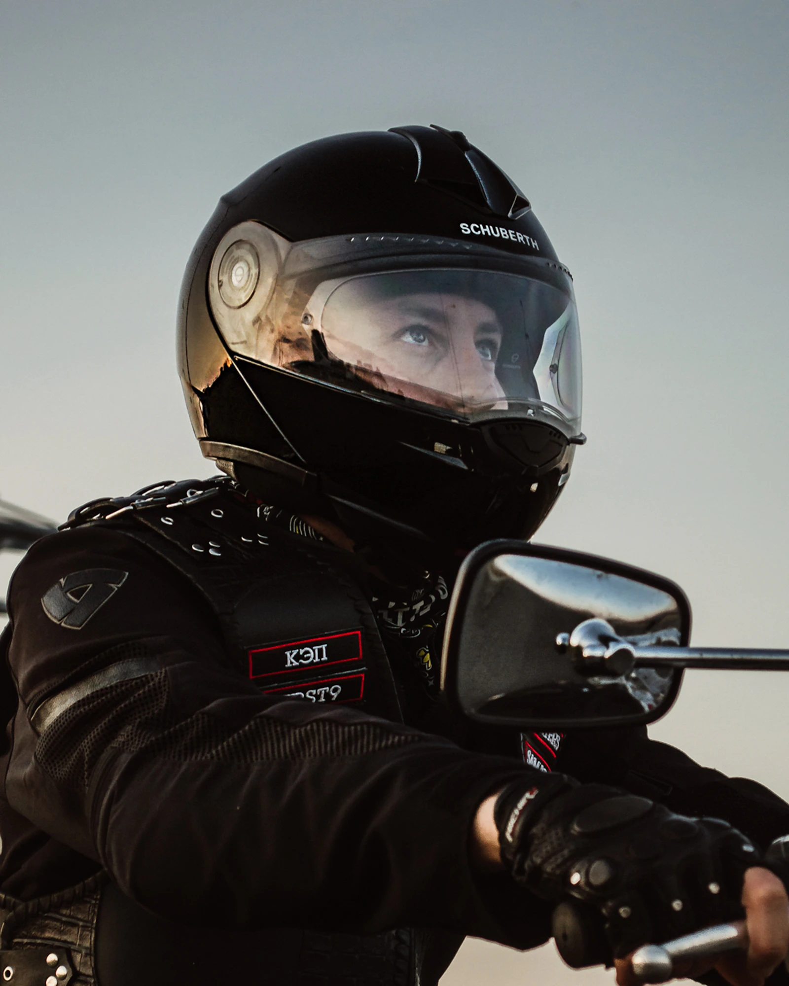 Man wearing a black helmet riding a motorcycle