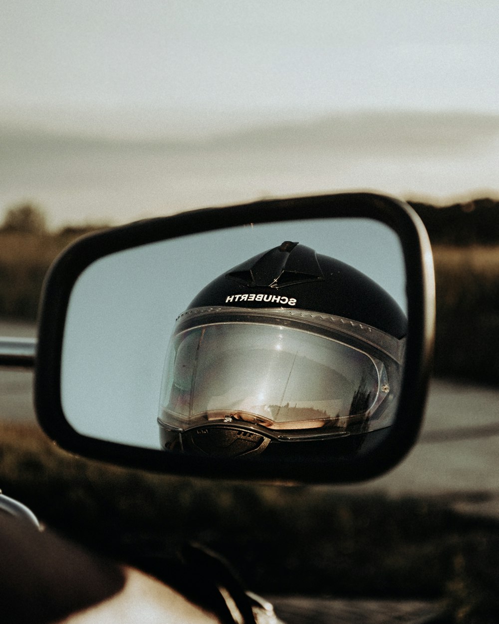 shallow focus photo of photo of person wearing black full-face motorcycle helmet