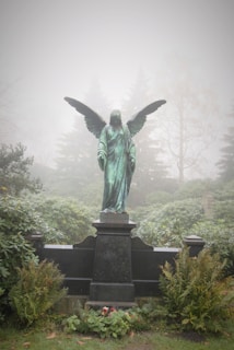 angel statue surrounded with trees