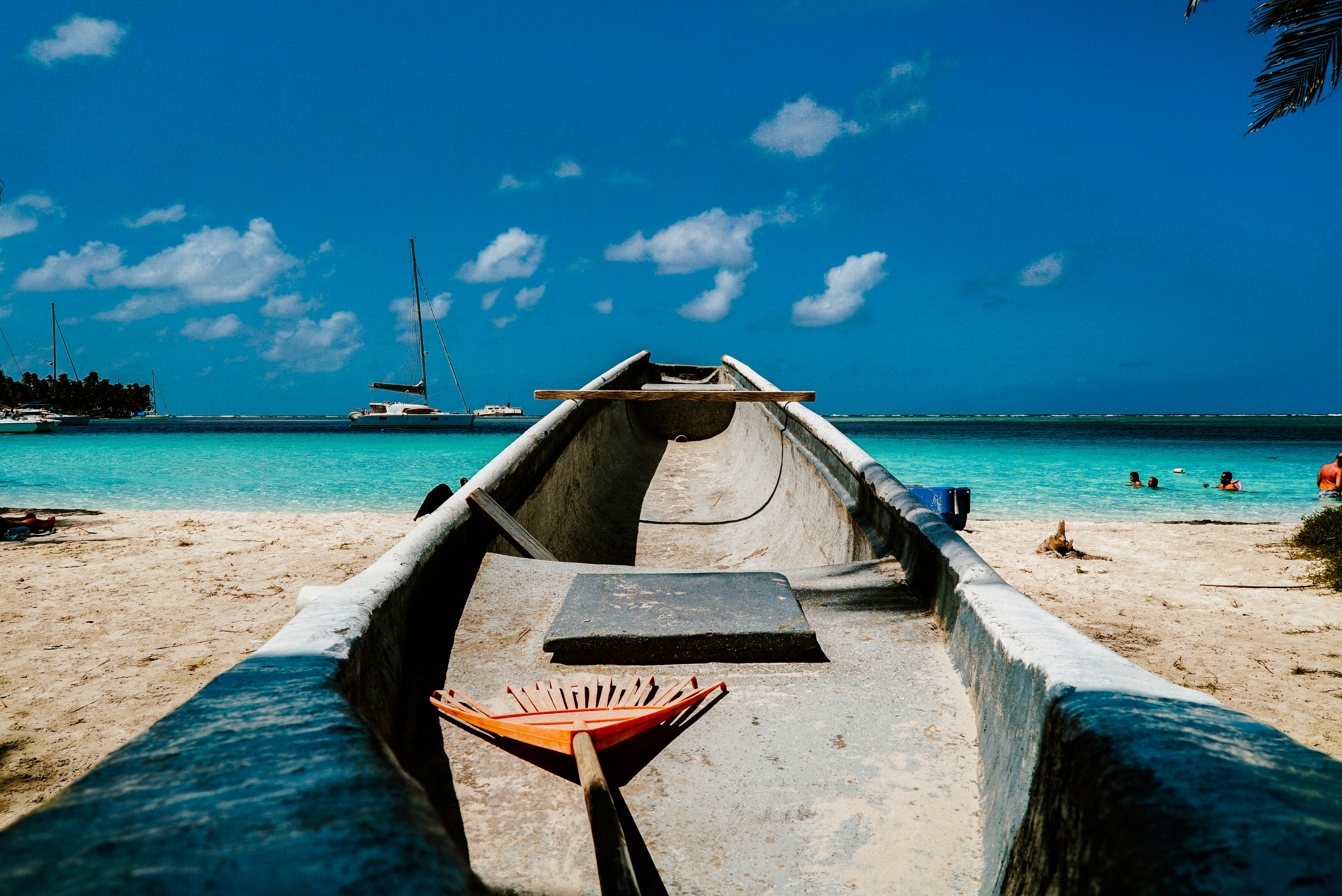 Boat lying at the beach of an island in Panama at daytime with crystal clear water and a cloudy sky