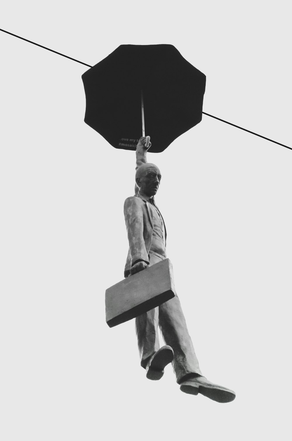 floating man holding umbrella statue