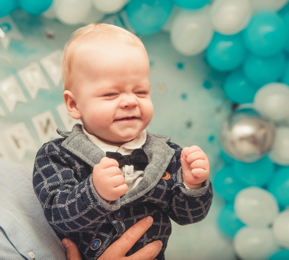 closed eyed baby boy wearing black bowtie