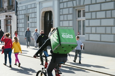 A bustling delivery rider from Butt Service AB navigating through Stockholm's charming streets on a sunny day.