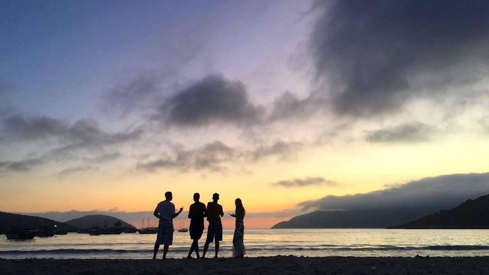 people standing at the beach during golden hour