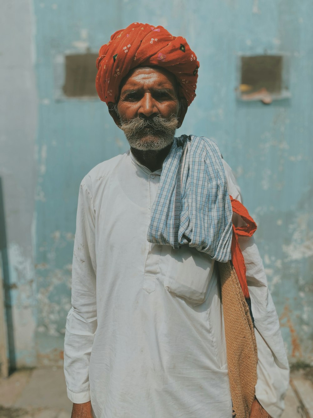 man wearing orange turban and white thobe