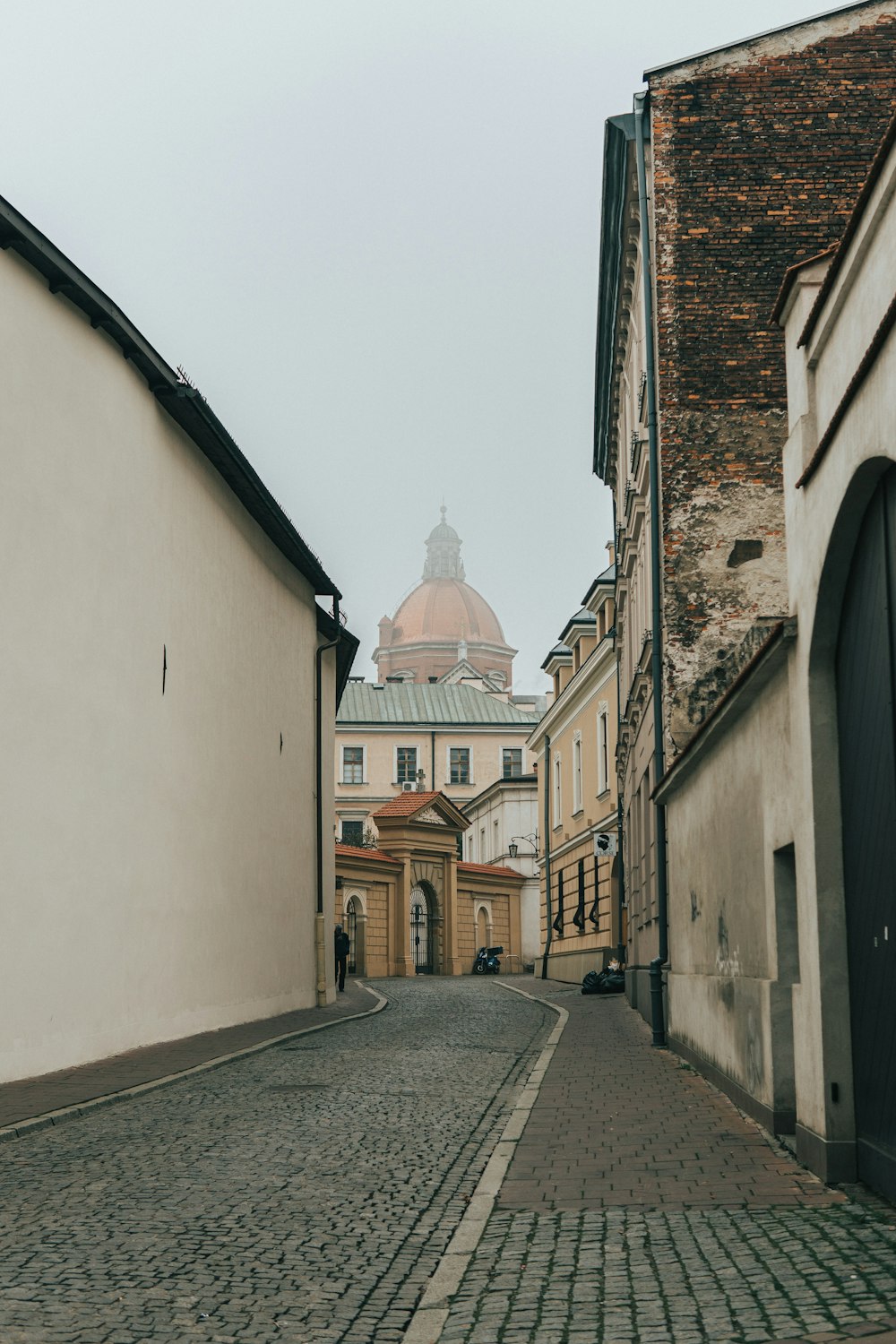 gray road in between buildings