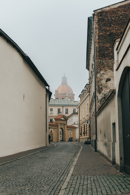 gray road in between buildings in Cloister of the Dominican Fathers Poland