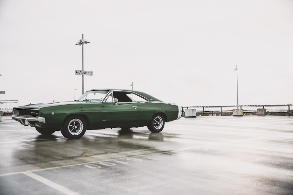 muscle car verde al parcheggio bagnato