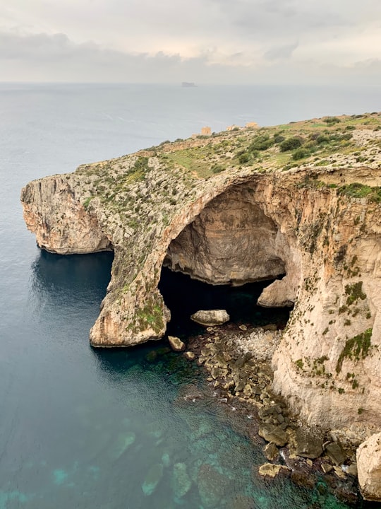 high-angle photography of green and gray stone hill in Blue Grotto Malta