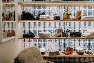 assorted-colored towel near brown leather boots on brown wooden shelf