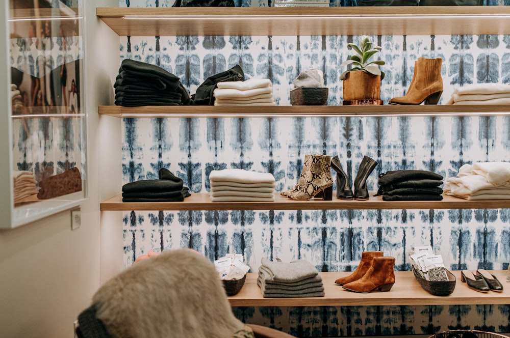 assorted-colored towel near brown leather boots on brown wooden shelf
