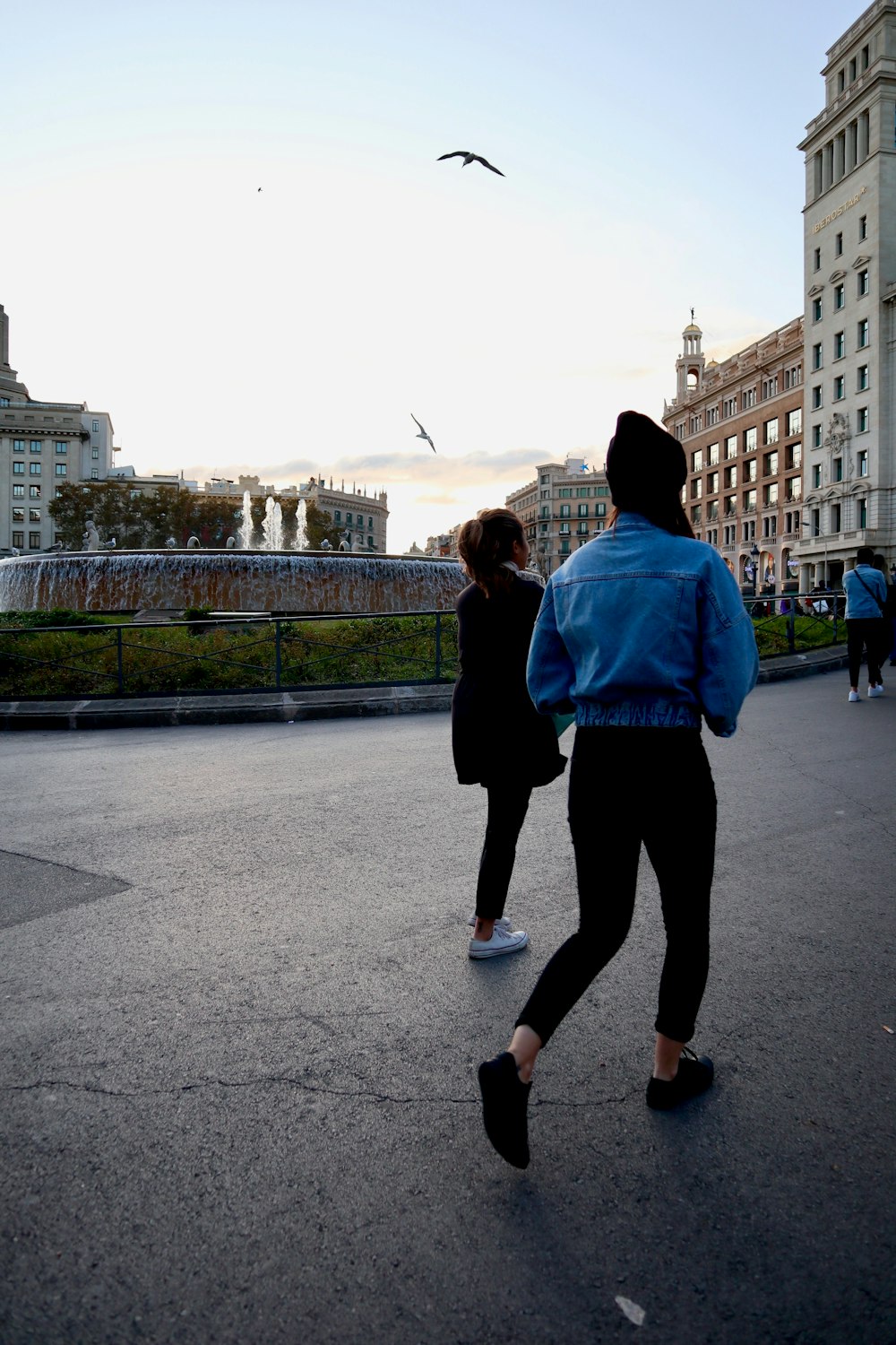 people walking near fountain and buildings during day