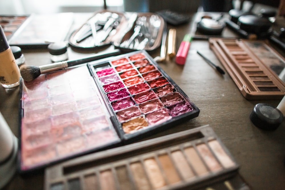 a table topped with lots of makeup and brushes