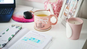 near full mug near unlit candle and laptop