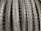 A row of neatly arranged, textured bicycle tires with prominent tread patterns. The tires are displayed vertically, showcasing the intricate details of the rubber surface.
