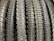 A row of neatly arranged, textured bicycle tires with prominent tread patterns. The tires are displayed vertically, showcasing the intricate details of the rubber surface.