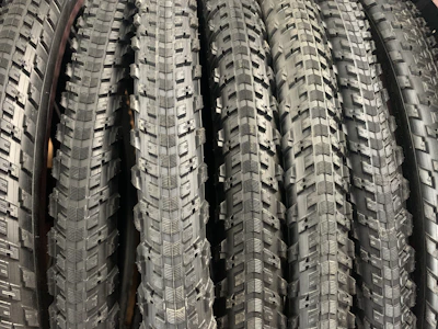 A set of durable motorcycle tires stacked neatly in a bright showroom